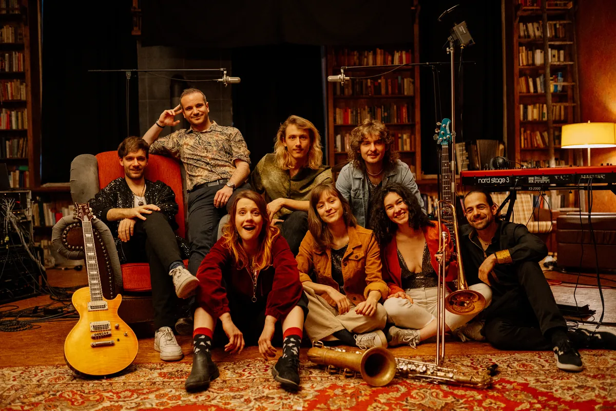The Keeds bei der Studio-Session, die Band sitzt und steht um einen Ledersessel